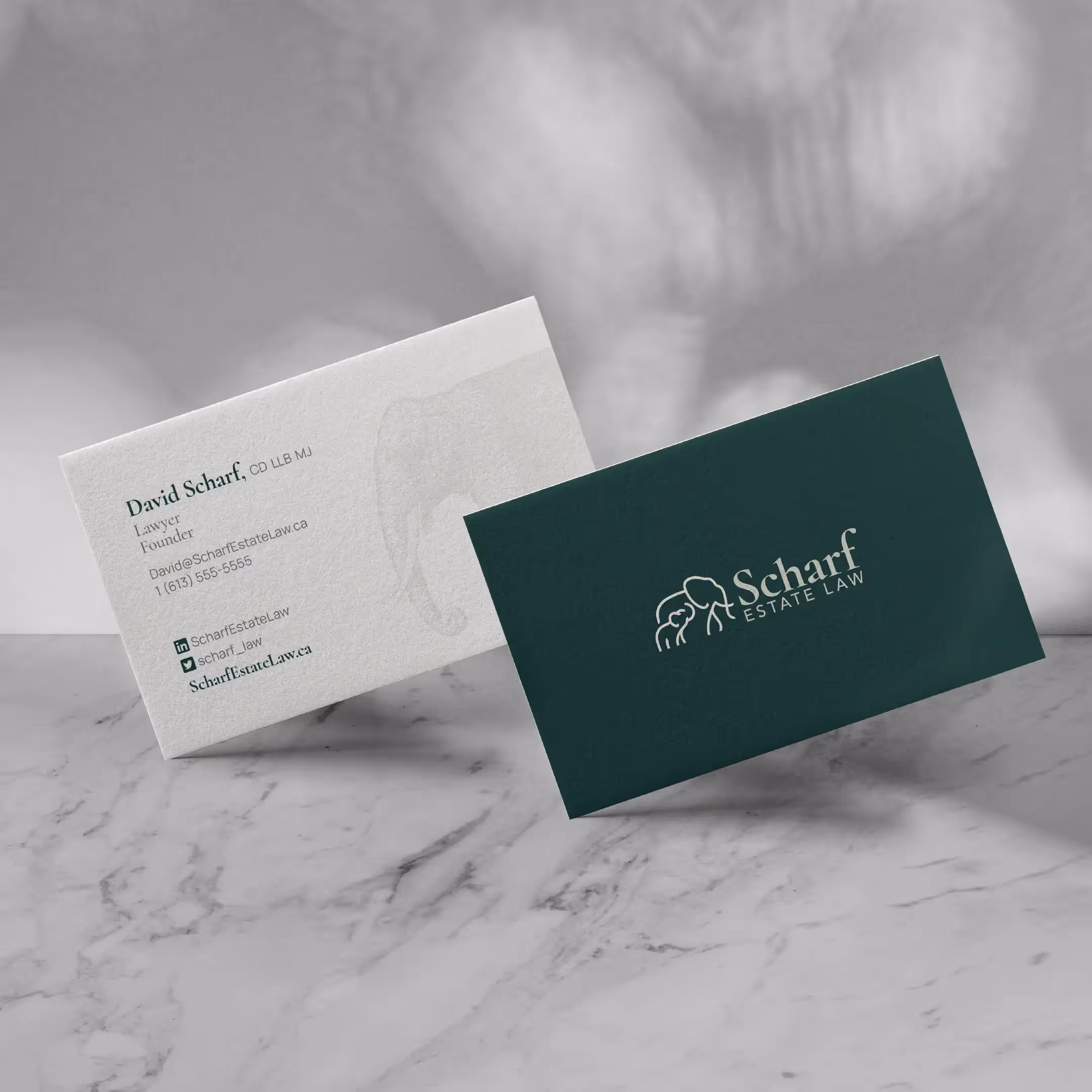 The Scharf Estate Law business cards, situated on a marble table.