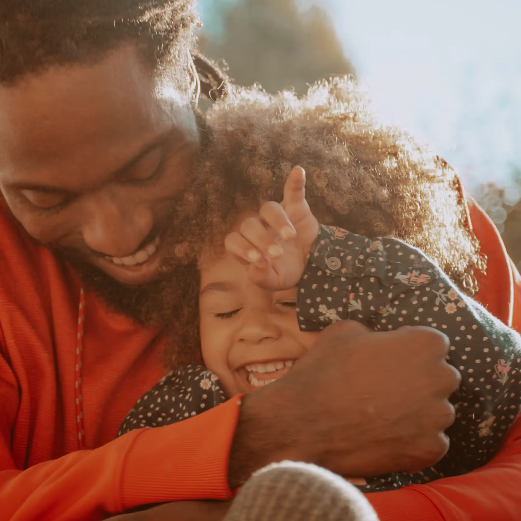 close up of a father and daughter snuggling and laughing.