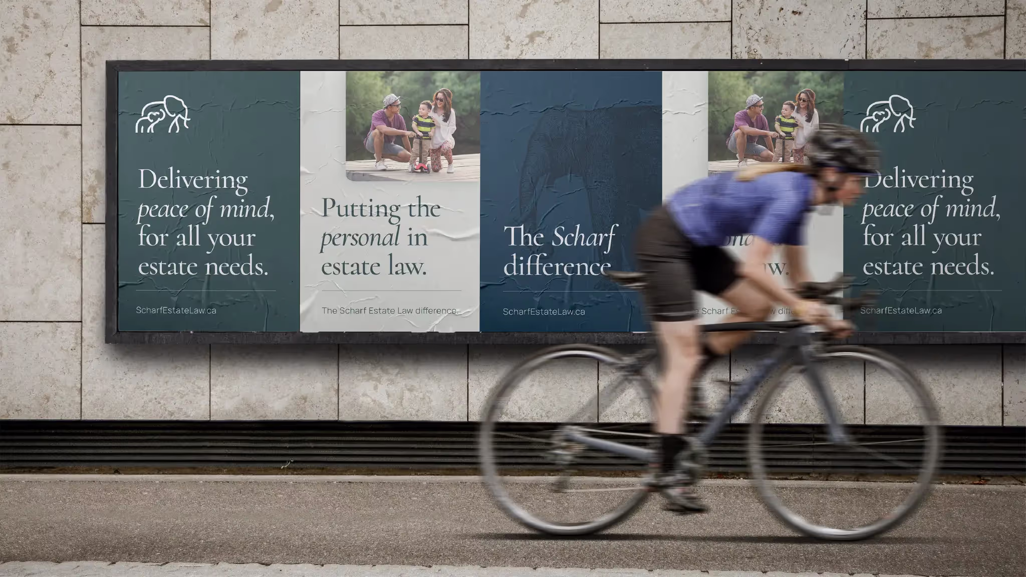 A street scene with a bicyclist riding in front of a set of posters for Scharf Estate Law that note that the company delivers peace of mind and puts the personal in estate law services.
