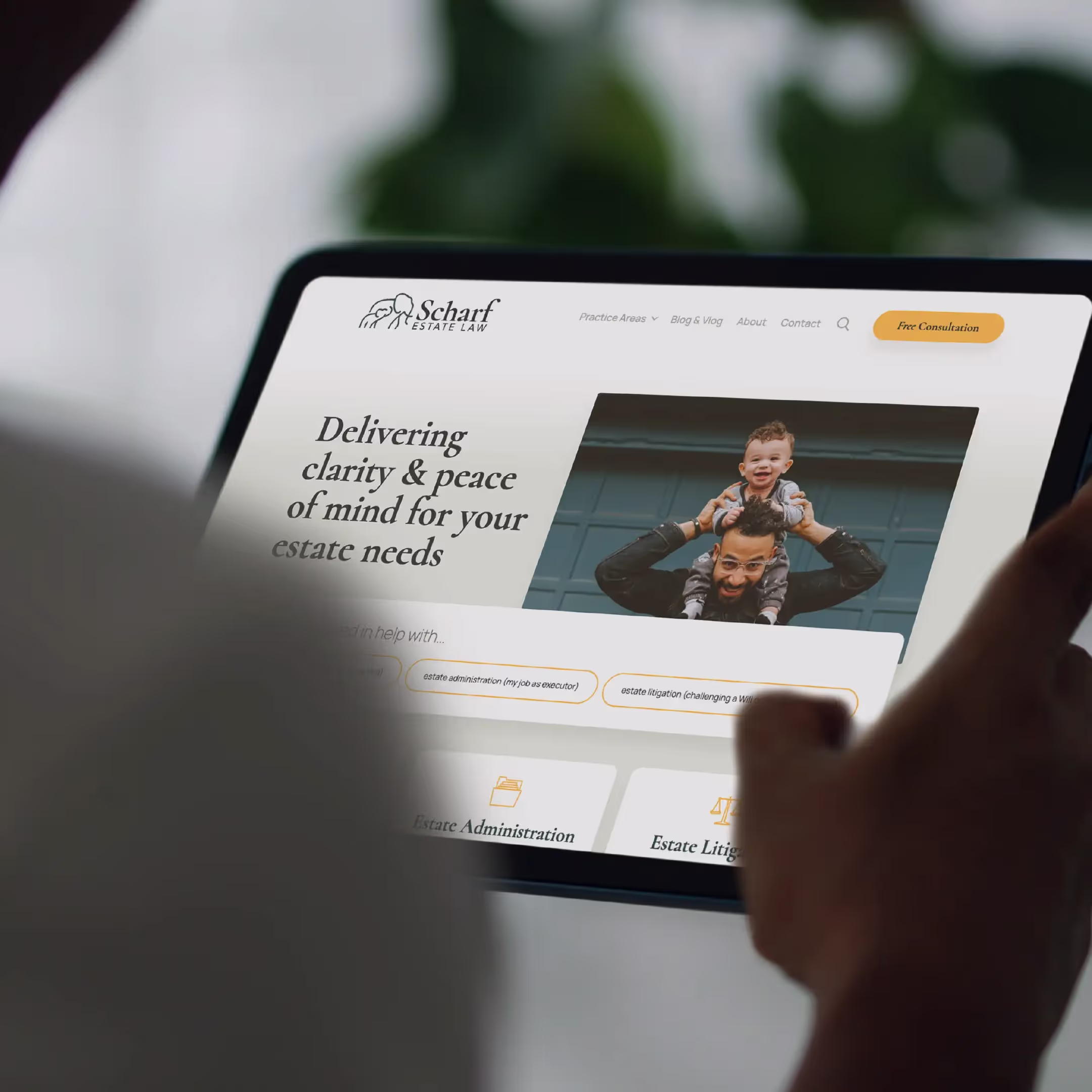 A man looking at an ipad that is displaying the Scharf Estate Law website